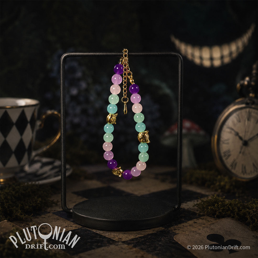 Nothing But the Grin - Alice in Wonderland inspired beaded bracelet. Violet, pink and turquoise glass beads with antique gold-tone grinning cat head beads hanging on a stand on a chequered table. Clocks, teacups and mushrooms surround it and a disembodied grin floats behind. Plutonian Drift.